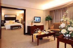 a hotel room with a bed and a living room at Changchun Huatian Hotel in Changchun