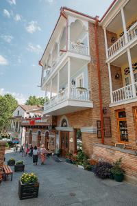 a building with a balcony and people walking in the street at Hotel Aivani Old Tbilisi in Tbilisi City