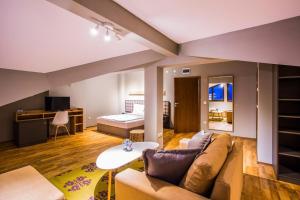 a living room with a couch and a bed at Sunny Hills Ski&Wellness in Pamporovo +58 photos