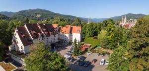 une vue aérienne sur une ville avec des voitures dans un parking dans l'établissement Hotel Restaurant & Spa Verte Vallée, à Munster