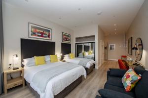 1 dormitorio grande con 2 camas y sofá en The James Suites, en Derry Londonderry