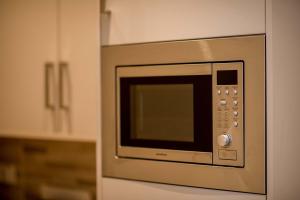 una cucina con forno a microonde in acciaio inossidabile di The James Suites a Londonderry