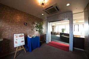 una sala de reuniones con una mesa y una pintura en una habitación en Hotel Satsukien, en Kanoya