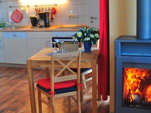 a kitchen with a wooden table and a fireplace at PONTUS Ferienwohnung FeWo4 in Zislow