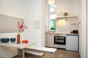 una cucina con elettrodomestici bianchi e un tavolo con mele di Newton-Appartement mit 3 Schlafzimmern a Berlino