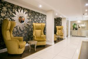 a waiting room with yellow chairs and a mirror at Hotel 224 & Apartments in Pretoria