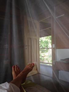 a persons feet on a bed in a room with a window at Finca El Regalo in Capurganá