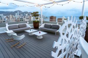 a rooftop deck with white furniture and a view of the city at Hotel Madeira Centro in Benidorm