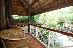 a balcony with wicker chairs and a view of trees at Sala Prabang Hotel in Luang Prabang
