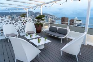 einen Balkon mit Stühlen und Tischen auf einem Schiff in der Unterkunft Hotel Madeira Centro in Benidorm