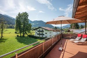 balkon z parasolem i widokiem na dom w obiekcie Appartement Annabella w mieście Söll