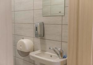 Miego namai في غارغزداي: حمام مع حوض وهاتف على الحائط