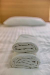 a stack of towels sitting on a bed at Miego namai in Gargždai