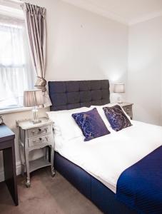 a bedroom with a bed and a nightstand with a window at MARS Hotel Seaview Blackpool in Blackpool