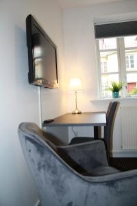 a room with a desk and a chair and a tv at Hotel Aarhus City Apartments in Aarhus
