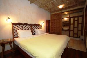 a bedroom with a bed and a bathroom with a sink at Sala Prabang Hotel in Luang Prabang