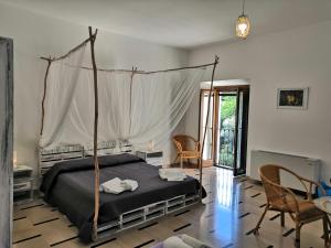 a bedroom with a canopy bed and a table and chairs at Casa Vacanze La Villa in Morino
