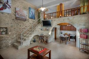 a living room with a staircase and a living room with a table at Pagonas Traditional House in Mouríon