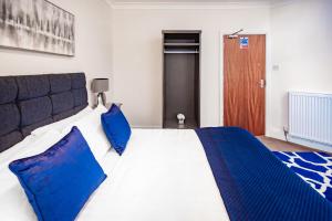 a bedroom with a large bed with blue pillows at MARS Hotel Seaview Blackpool in Blackpool +54 photos