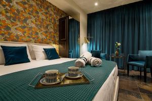 ein Hotelzimmer mit einem Bett und einem Tablett mit Essen darauf in der Unterkunft Athens Imperial Suites - Luxury Living in Athen