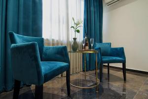 a room with blue chairs and a table and a window at Athens Imperial Suites - Luxury Living in Athens