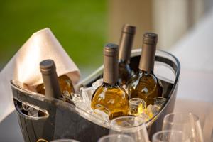 a basket of wine bottles and glasses on a table at Relais Bellaria Hotel & Congressi in Bologna