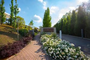 a garden with white flowers next to a sign at Relais Bellaria Hotel & Congressi in Bologna