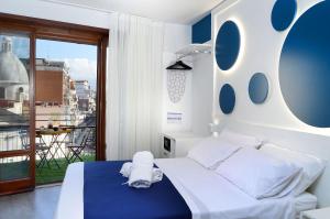 a bedroom with a white bed and a balcony at Napoli Central Station Studio in Naples