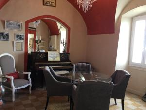 a room with a piano and chairs and a mirror at Hotel de la Plage Santa Vittoria in Algajola