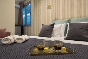 ein Tablett mit Getränken und Handtüchern auf dem Bett in der Unterkunft Athens Imperial Suites - Luxury Living in Athen