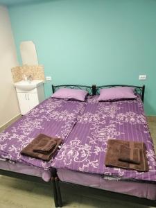 a purple bed with two towels on top of it at Hostel Meridian in Kyiv