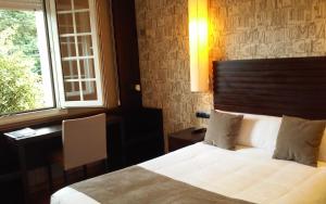 sypialnia z łóżkiem, biurkiem i oknem w obiekcie Hotel Gastronómico Casa Rosalia w mieście Brion