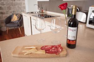 una bottiglia di vino e due bicchieri di vino e carne e formaggio di 22 THE STRADUN a Dubrovnik Altre 7 foto
