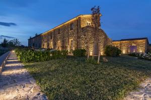 a large stone building with lights on the side of it at Capanna Suites in Montalcino