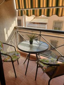 a table and chairs on a balcony with a potted plant at Céntrico, cerca de la playa con aparcamiento privado gratis in Águilas