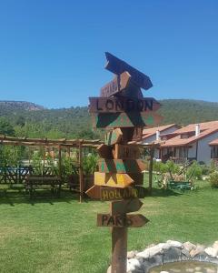 a wooden sign with street signs on a pole at Tefenni Villas & Hotel in Tefenni