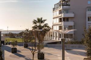 een gebouw met palmbomen ervoor bij Michel-Ange, Appartement avec Terrasse et Parking in Marseille