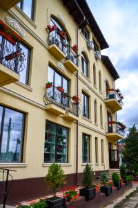 un edificio con balconi e piante in vaso di Hotel Coquette a Măneciu