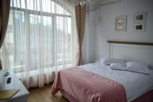 a bedroom with a bed and a large window at Hotel Coquette in Măneciu