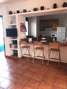 カレタ・デ・ファマラにあるApartamento Inmaのキッチン(椅子2脚、テーブル、カウンター付)