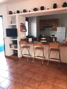 a kitchen with two chairs and a table and a counter at Apartamento Inma in Famara