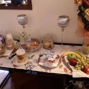 a table topped with plates of food and fruit at Posada Serena in Bologna