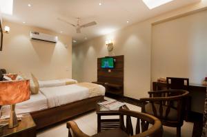 a bedroom with a bed and a desk and a tv at Imperial Apartment Fortis in Gurgaon