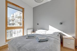 a bedroom with a large bed with two towels on it at Holiday Apartment near the Sea - free private parking in Gdańsk