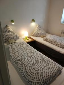two beds in a room with a lamp on a table at Grenaa Bed and Breakfast in Grenå