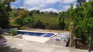 einen Pool mit 2 Liegestühlen und einem Pool in der Unterkunft CHÁCARA SANTA TERESA in Triunfo