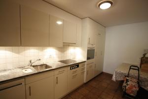 a kitchen with white cabinets and a sink at Apartment International in Crans-Montana