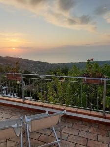 un banc assis sur un balcon avec vue sur le coucher du soleil en arrière-plan dans l'établissement B&B La Scapola, à Mattinata