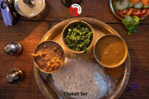 Hotel Fewa Corner & Restro في بوخارا: طاولة عليها رز وأوعية طعام