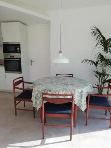 Plurien的住宿－Esprit Cottage "4 étoiles" sables d'Or les pins，餐桌、两把椅子、一张桌子和一张桌布